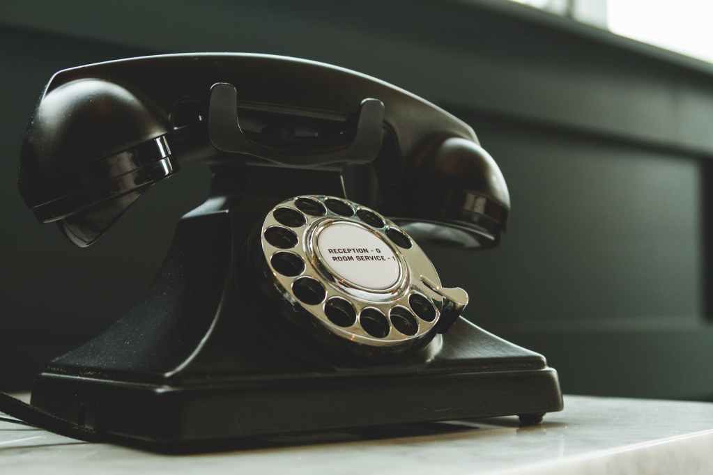 black rotary telephone on white surface, encouraging you to call recapture your memories