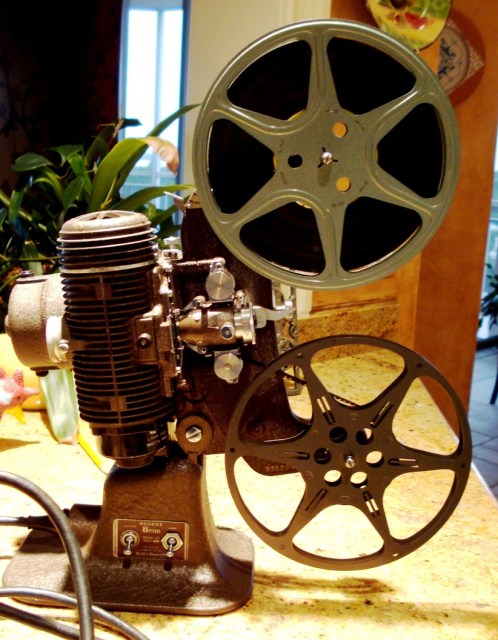 A picture of an 8mm projector, with film reels on it. Transfer 8mm film to DVD.